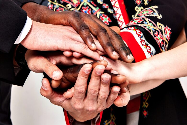 Diverse multigenerational hands stacked together, symbolizing family unity, support, and the bond of grandparenting.