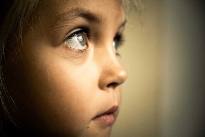 Close-up profile of a thoughtful young child looking upward, evoking curiosity, innocence, and the bond between grandparents and grandchildren.