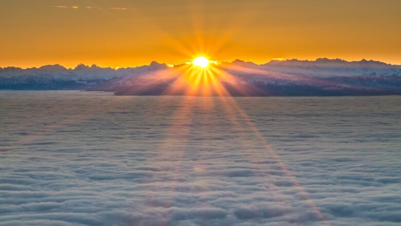 Sunrise over snow-covered mountains above a sea of clouds, a peaceful nature scene for a grandparenting page.grandparenting family moment.
