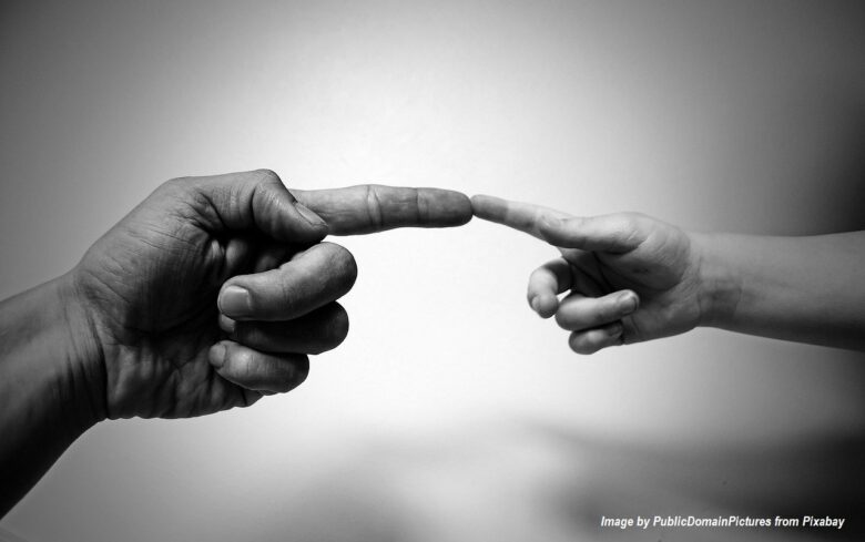 Black-and-white image of an adult and child gently touching index fingers, symbolizing family connection, intergenerational love, and caring relationships.