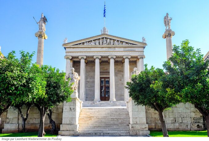 Neoclassical Greek university building with Corinthian columns, statues, marble steps, and surrounding trees under a clear blue sky, representing education and intergenerational learning for CaringGrandparents.com.