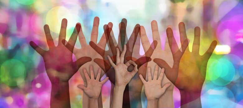 Multigenerational hands raised together against a colorful background, symbolizing family connection, support, and grandparenting.