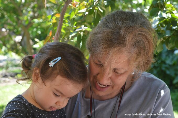 Grandmother sharing a moment with her granddaughter outdoors in a leafy garden