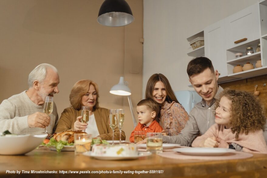 Multigenerational family sharing a meal at the dinner table, with grandparents, parents, and children celebrating family bonding, togetherness, and grandparenting.