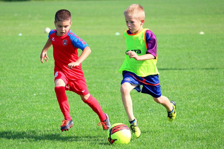 Two boys playing soccer on a green field, showing active family fun and a multigenerational grandparenting lifestyle