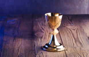Gold chalice on a wooden table, symbolizing tradition, family heritage, and meaningful grandparenting moments.