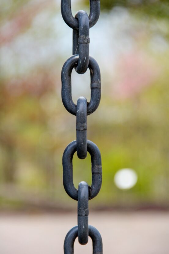 Vertical close-up of a black metal chain, symbolizing connection and strength in multigenerational grandparenting relationships.