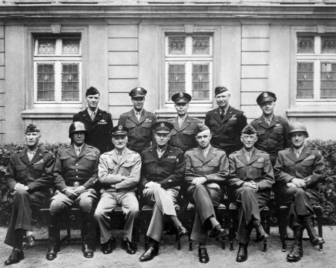 Black and white group portrait of military officers seated and standing outside a building, a historic family legacy image that can support grandparenting, service, and generational history content.