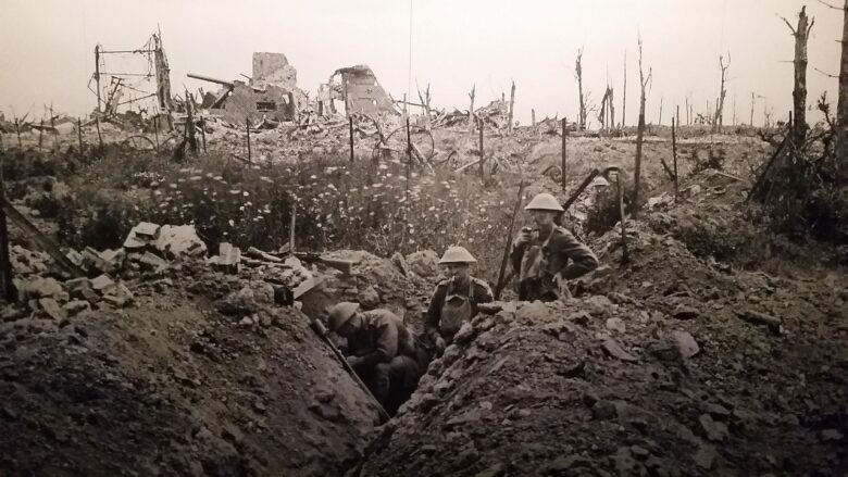 Historic black and white war scene with soldiers in a trench amid разрушенные battlefield ruins, a generational history image that can support grandparenting themes of sacrifice, resilience, and family legacy.