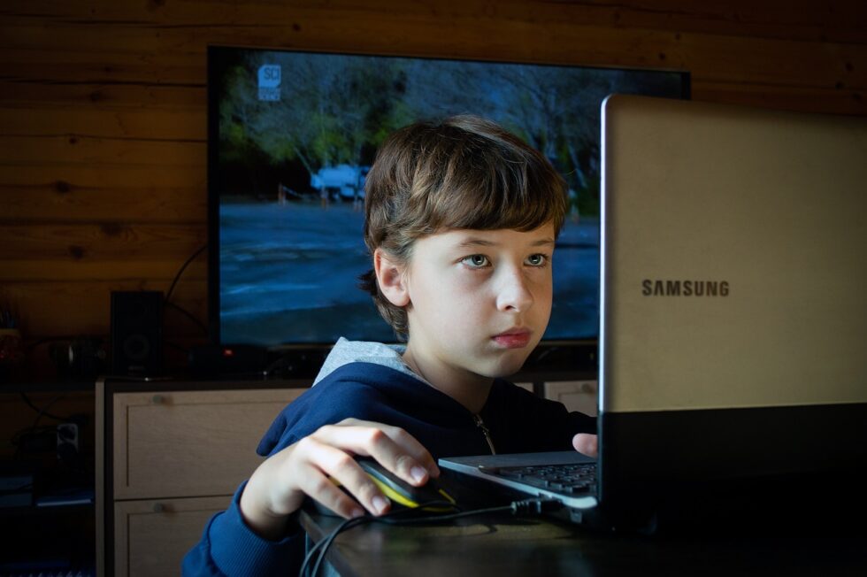 Young child using a laptop at home, showing screen time, learning, and family technology use