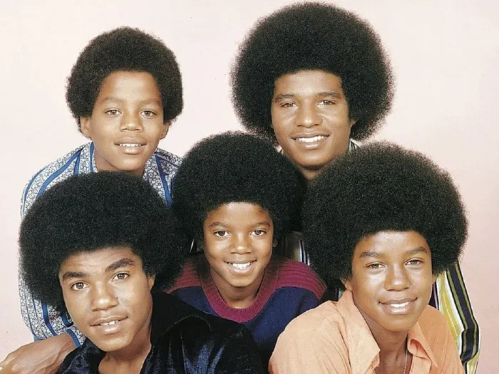 The Jackson 5 members members posing together in a vintage portrait, with a strong sense of togetherness and multigenerational family connection.