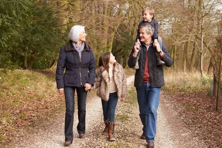 Grandparents walking happily with grandchildren creating deeper bond with them.