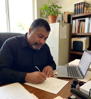 James Lott, Jr writing a letter to granddaughter Scarlet as a way of staying connected to her.